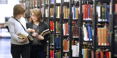 Students looking at books in the library