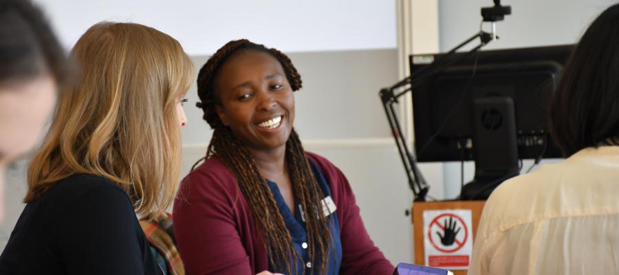 A pair of women discussing  next to a table