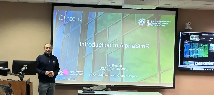 Ivan Pocrnic standing at the front of the room beside a screen introducing the workshop