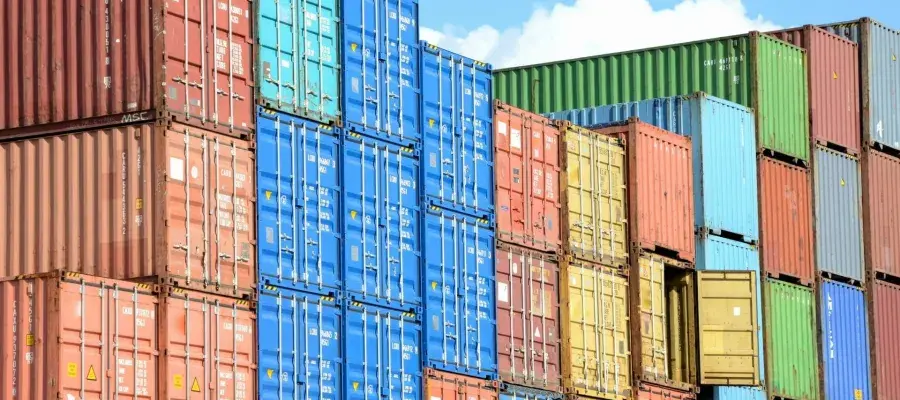 Coloured shipping containers are stacked up in a port.