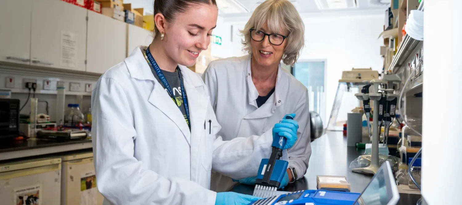 Two women in a lab, sharing a happy moment