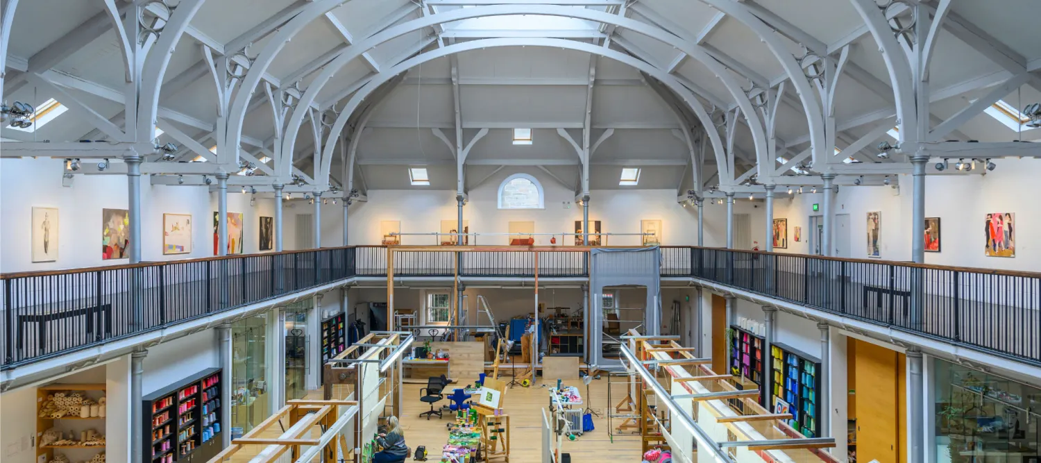 The interior of Dovecot from on high showing a large space and buzzing activity below