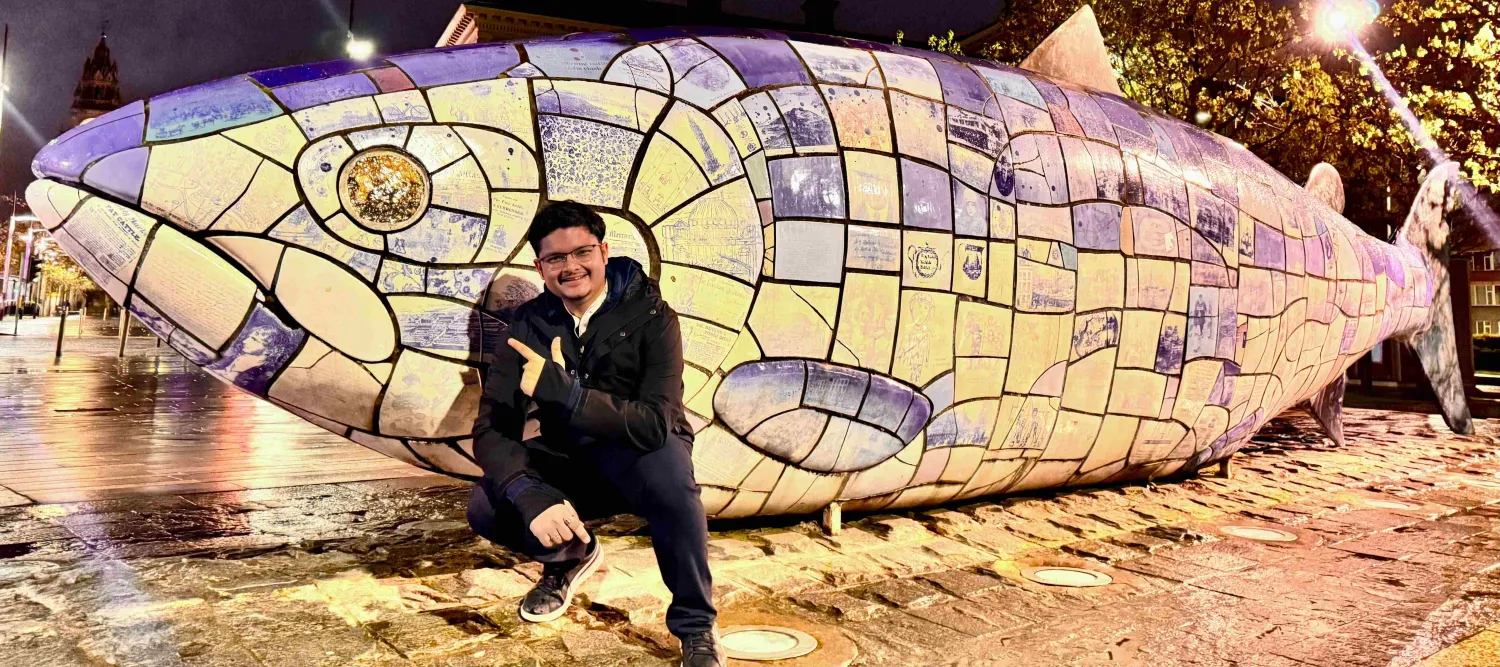 Anoorag next to a giant fish statue
