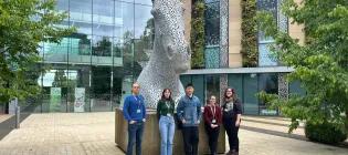 Pocrnic Lab members standing in front of a kelpie statue