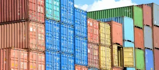 Coloured shipping containers are stacked up in a port.