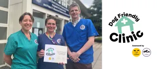 three people in clinical scrubs stand outside Hospital for Small ANimals, holding a certificate and smiling to the camera
