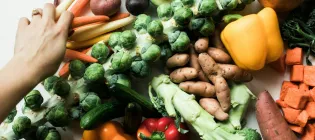 A selection of vegetables: brussel sprouts, sweet potato, peppers