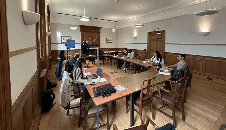 Workshop attendees sitting around a table listening to a presenter