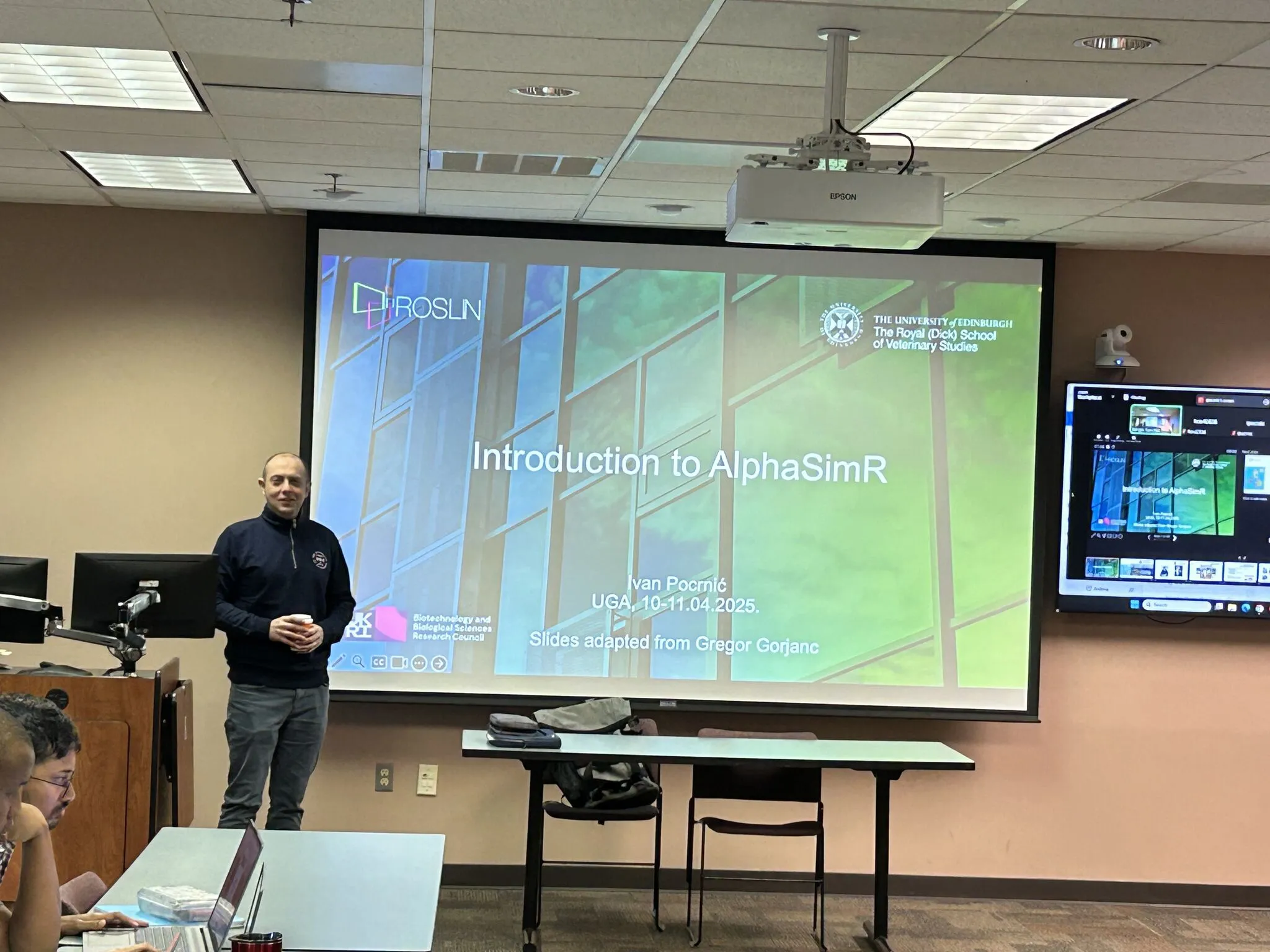 Ivan Pocrnic standing at the front of the room beside a screen introducing the workshop