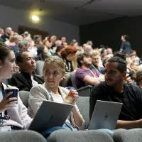 Audience at the lecture. People pictured with laptops at the forefront.