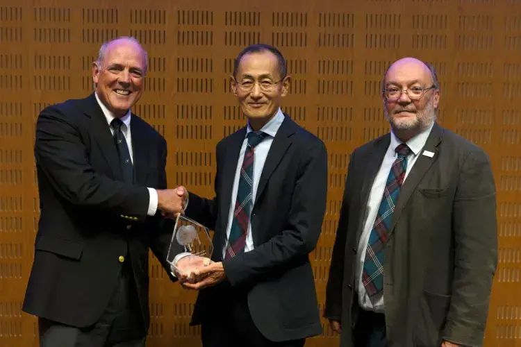 Head of the Roslin Foundation, John Brown, shakes Prof Yamanaka's hand, while Prof Whitelaw stands next to them.