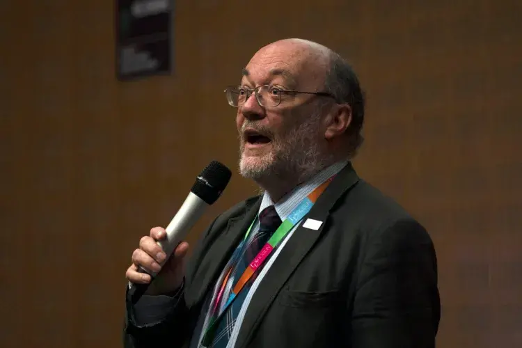 Prof Bruce Whitelaw speaking, holding a microphone