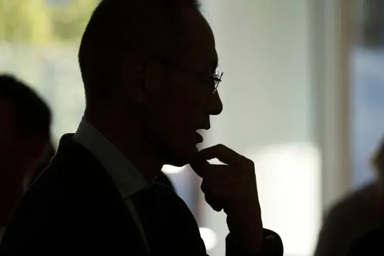Dark silhuette of Prof Yamanaka, from a side profile against a light background.