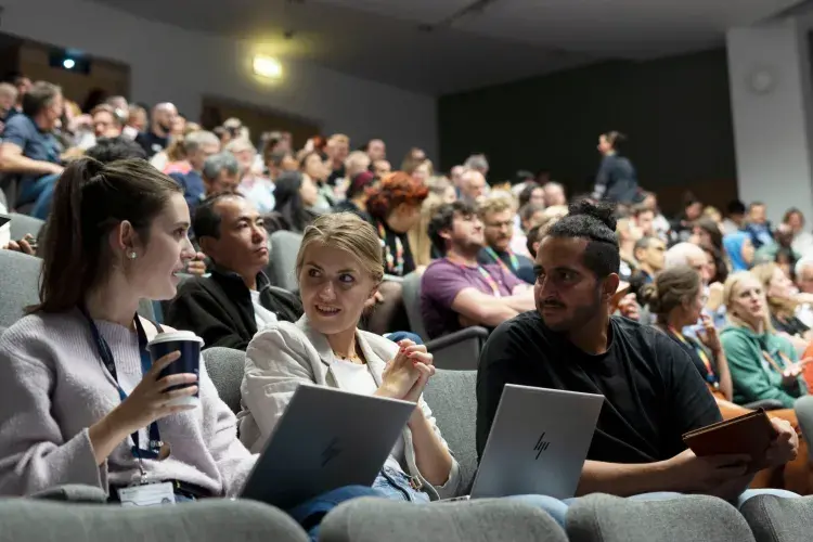 Audience at the lecture. People pictured with laptops at the forefront.