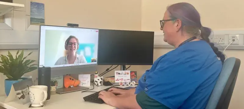 image of female vet sitting at a desk talking to a female client on a computer screen