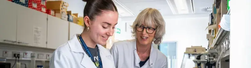 Two women in a lab, sharing a happy moment