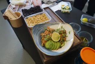 A bowl of vegan food with chickpeas, avocado, and fresh herbs.