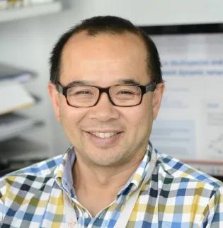 Professor Rowland Kao smiles while sitting at his desk