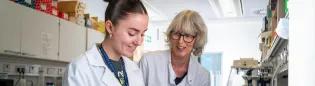 Two women in a lab, sharing a happy moment