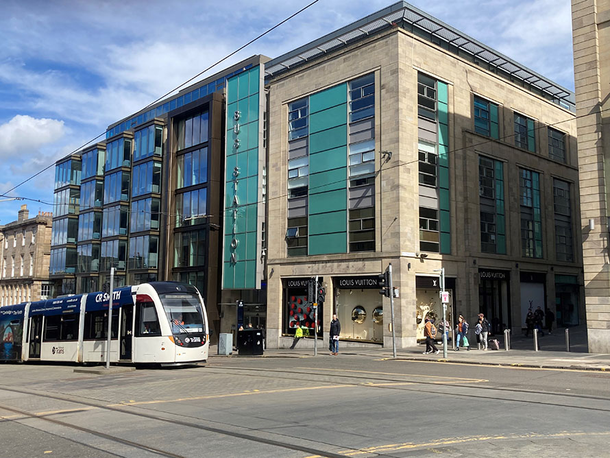 The bus station entrance in Edinburgh, with a tram in the foreground