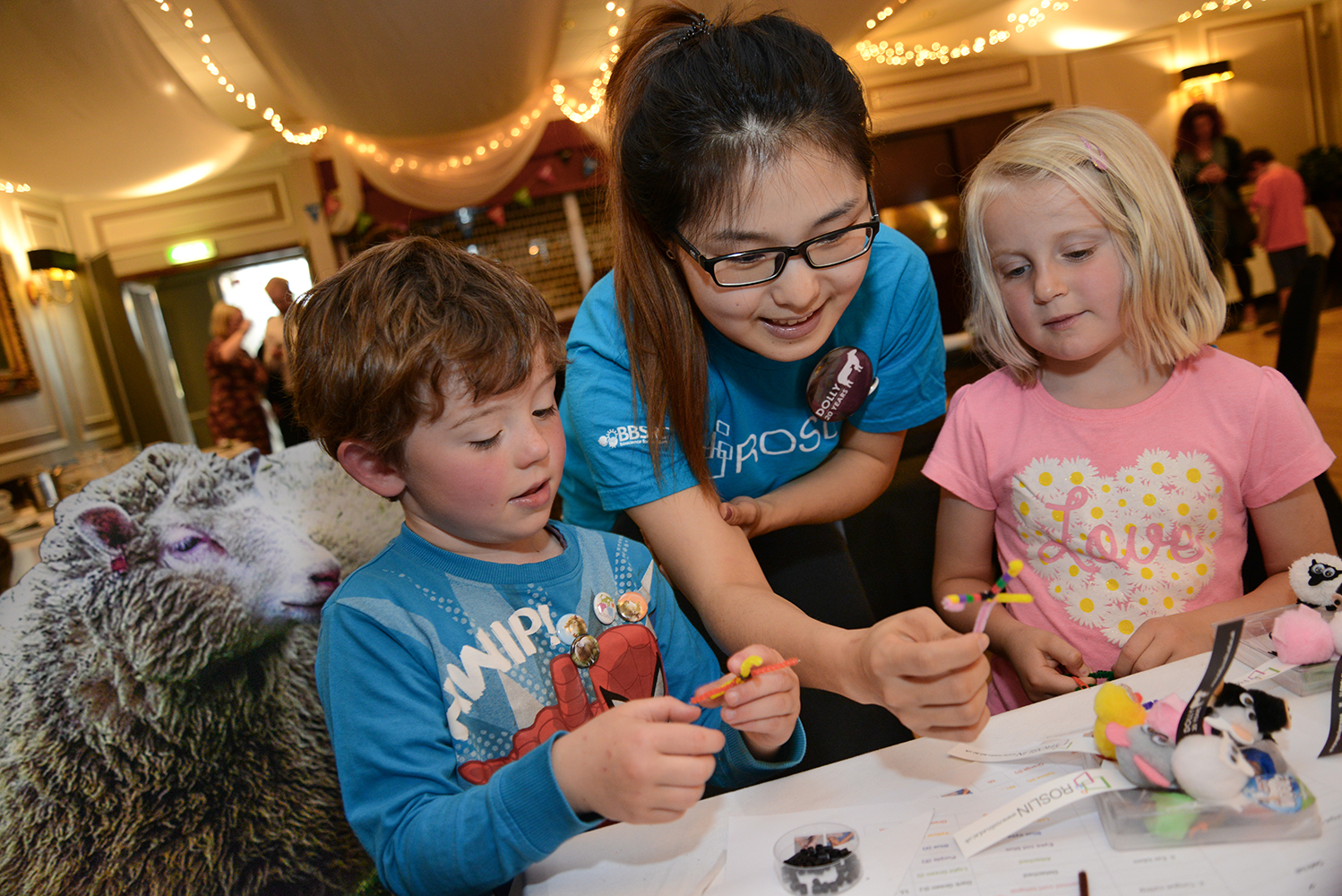 Roslin researcher and children making DNA chromosomes at Dolly 20th birthday party