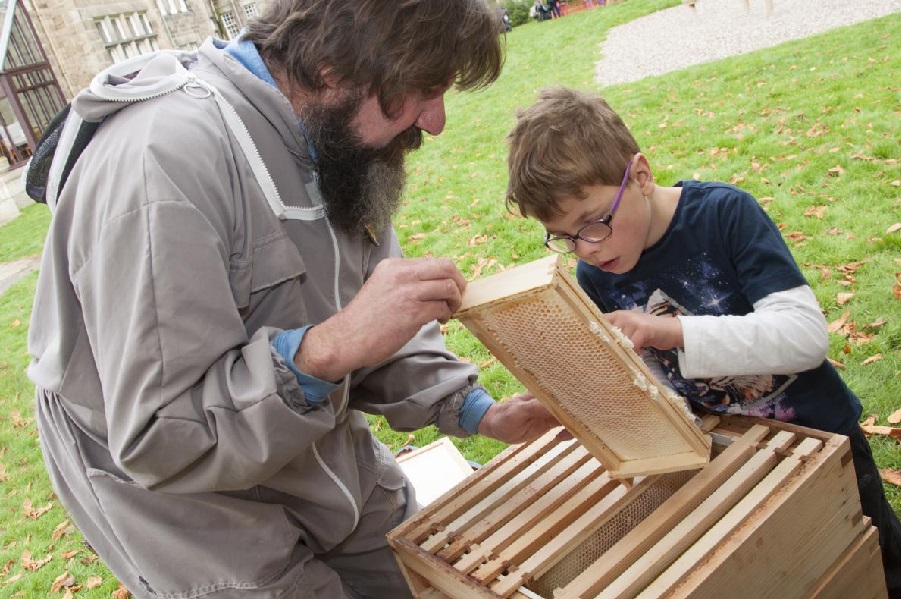 Scientist Dr Mark Barnett showing a young child the bee apiary