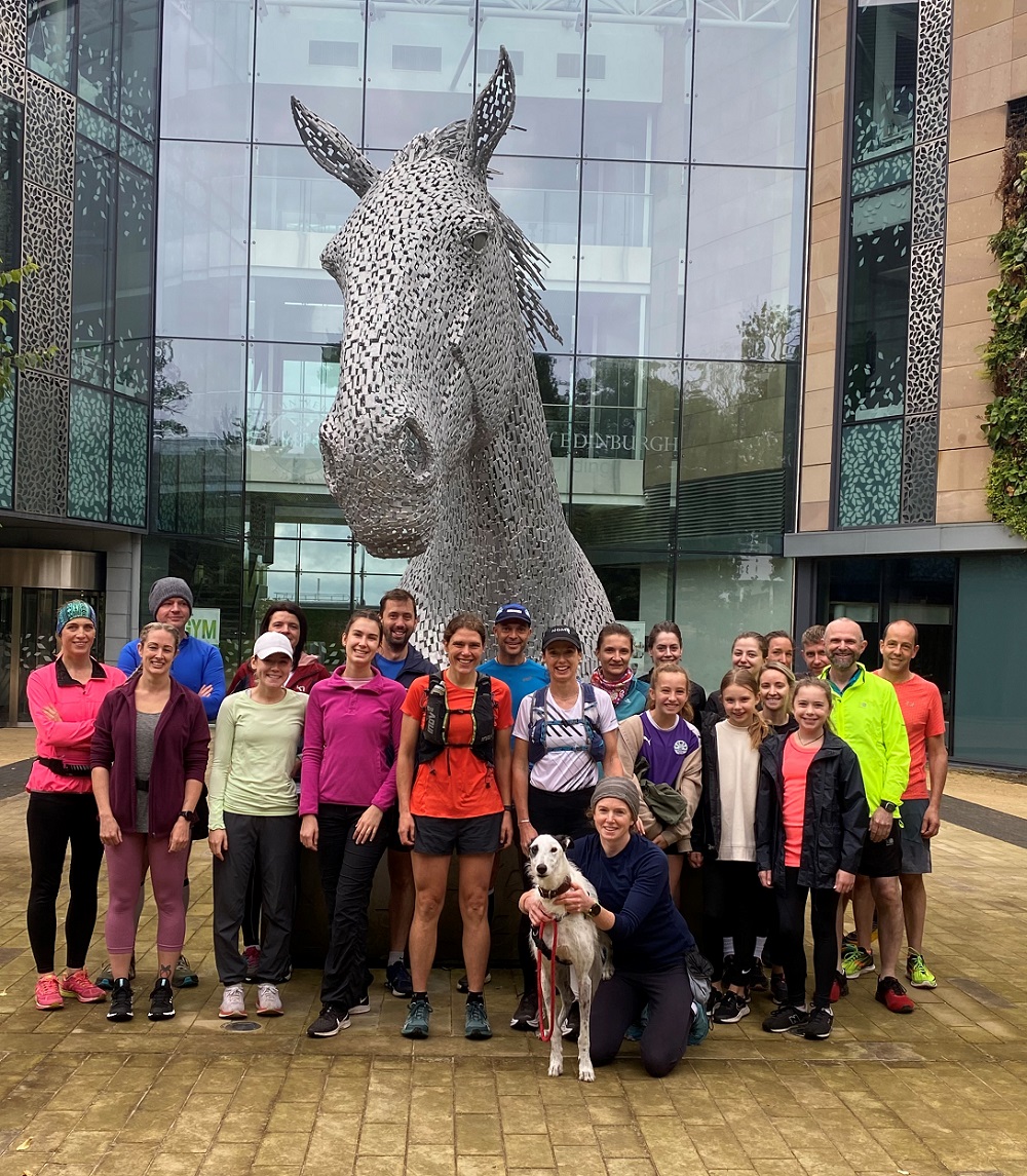 a group of staff and students wearing running clothes standing in front of a horse sculpture at Easter Bush Campus