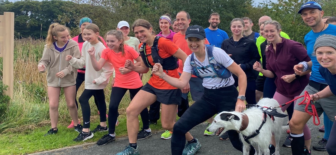 a group of runners pose ready to start a run together