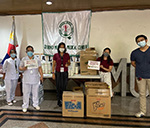 Several people facing the camera holding signs surrounded by boxes